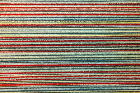 Colorful carpet with horizontal striped pattern in red, yellow, green and blue tones.の写真素材