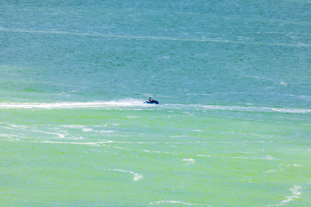 Person riding jet ski on Caribbean Sea with turquoise water under bright sunlight. Mexico. Cancun.の写真素材