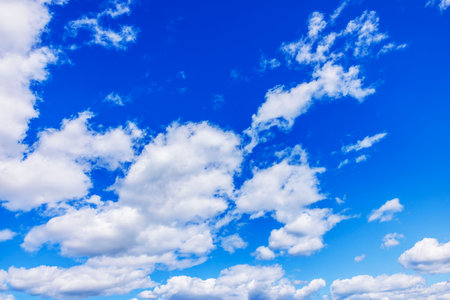White clouds floating across blue summer sky in bright daylight. Sweden.の写真素材