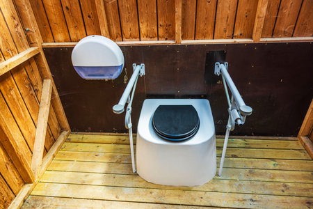 Accessible outdoor bio toilet with grab bars inside wooden hut for people with limited mobility. Sweden.の写真素材