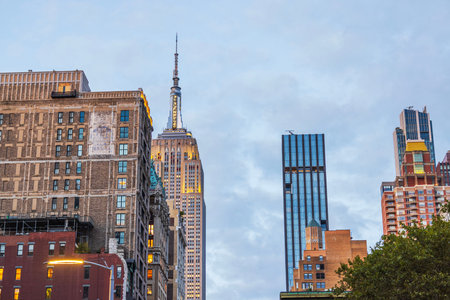 Empire State Building on background of residential and office buildings in New York City at sunset....