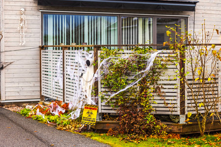 Close up view of Halloween decorated villa with ghost figure, skeleton, fake spider webs and beware of zombies sign. Sweden.の写真素材