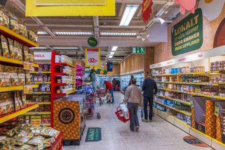 Beautiful view of supermarket aisle with shoppers selecting groceries from shelves during winter season.のeditorial素材