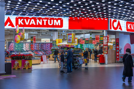 Beautiful view of Christmas flower display with poinsettias and tulips at supermarket entrance during holiday season.のeditorial素材