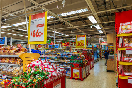 Festive Christmas decorations and holiday sale signs inside bright supermarket food aisle.のeditorial素材