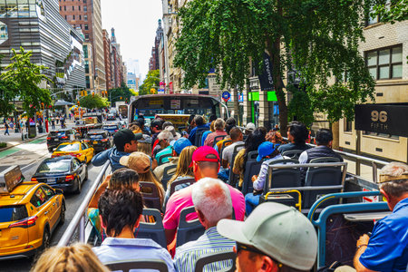 Beautiful view from open top tourist bus moving along Fifth Avenue in Manhattan with yellow taxis....