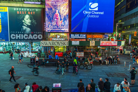 Beautiful view of Times Square at night with bright Chicago musical billboard above crowded street....