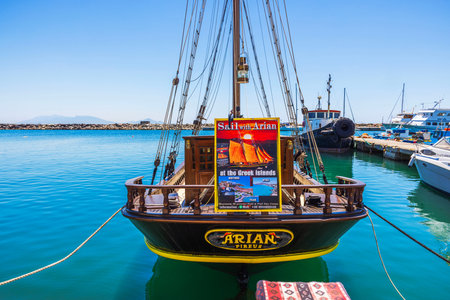Close up view of tourist sailing ship Arian moored at harbor pier with excursion advertisement...
