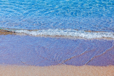 Close up view of gentle wave on sandy beach of Aegean Sea. Greece.
