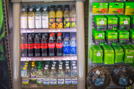 Close up view of refrigerated display with Coca Cola juice water bottles neatly arranged in store.