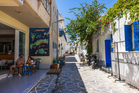 Beautiful view of cozy Mediterranean street with white houses blue shutters and blooming greenery in sunny day.  Kardamena. Greece.のeditorial素材