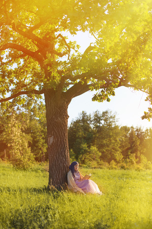 Woman reading book in the parkの写真素材