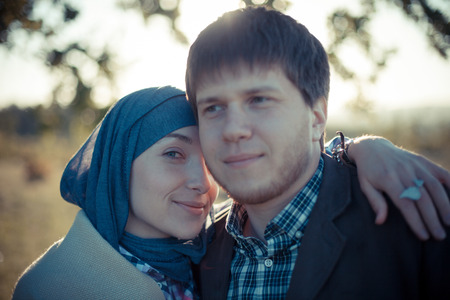 Cute young couple smiling at camera in the parkの写真素材