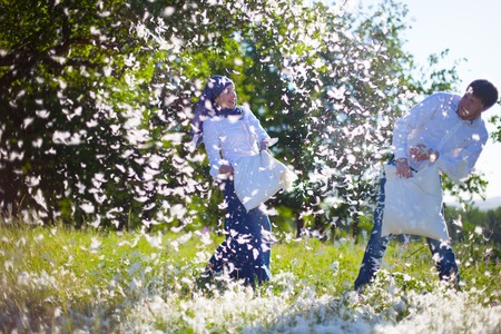 couple having a fun pillow fightの写真素材