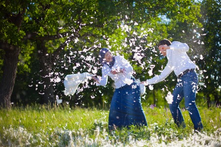 couple having a fun pillow fightの写真素材