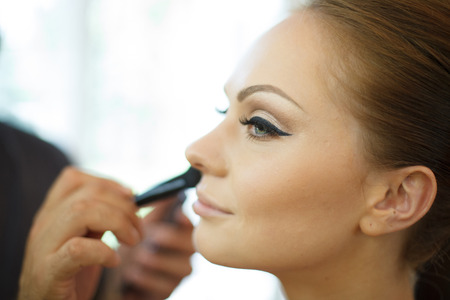 Horizontal photo of bride being made up by make up artistの写真素材