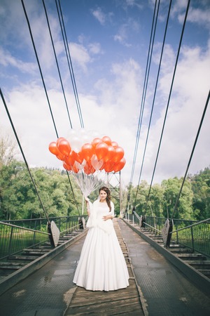 Beautiful bride on a bridge in front of lake.の写真素材
