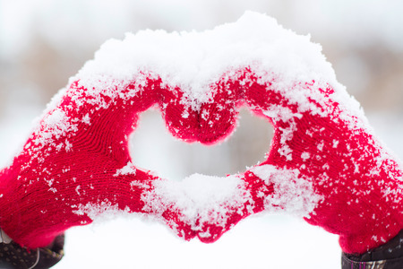 Making heart symbol with snowy handsの写真素材