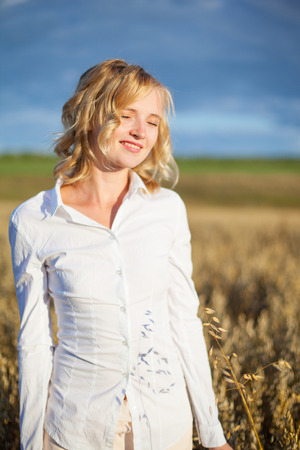 Young woman on wheat fieldの写真素材