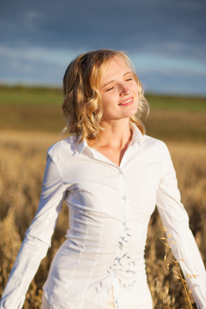 Beautiful woman standing in a grassy fieldの写真素材