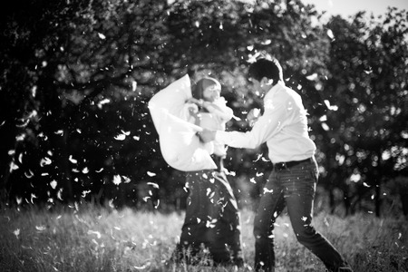 Couple having a pillow fight on field の写真素材