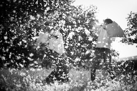 Couple having a pillow fight on field の写真素材