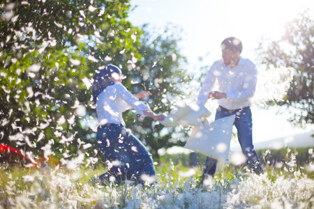 Couple having a pillow fight on field の写真素材