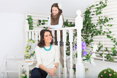 Lovely girls looking out over the porch railing.の写真素材