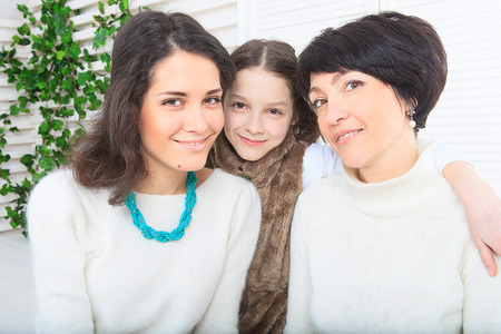 Cute little girl, her mother and grandmother together on this portraitの写真素材