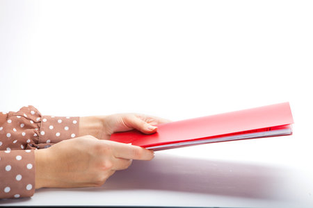 Close-up of female hands making notes in the notepad at office