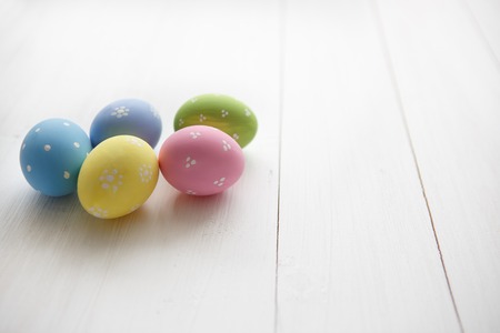 Colorful decorated easter eggs on white wood background. Happy Easter.の写真素材