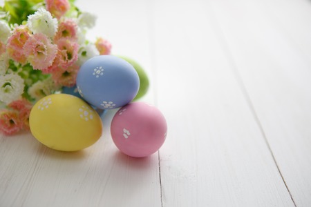 Colorful decorated easter eggs on white wood background. Happy Easter.の写真素材