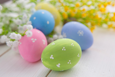 Colorful decorated easter eggs on white wood background. Happy Easter.の写真素材