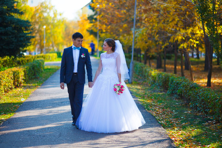 Happy newlyweds in park. Portrait of loving young bride and groomの写真素材