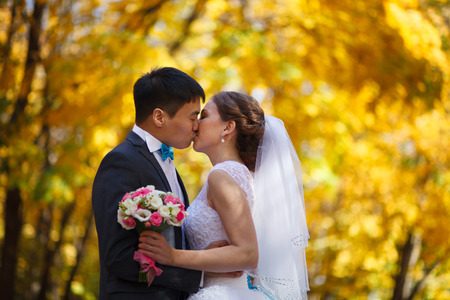 Happy newlyweds in park. Portrait of loving young bride and groomの写真素材