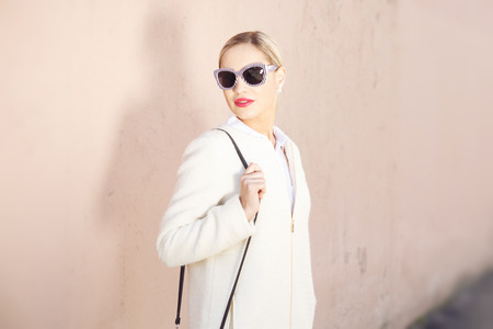 Young fashion beautiful woman in sunglasses on a city streetの写真素材