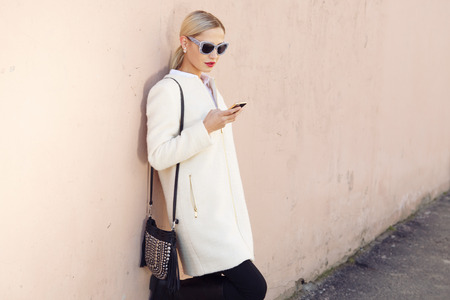 Young fashion beautiful woman in coat on a city streetの写真素材