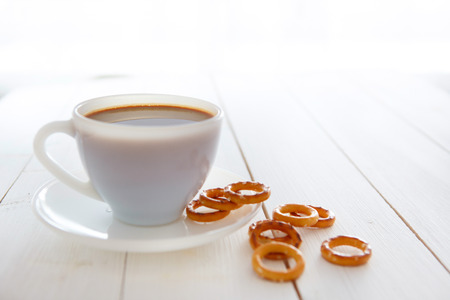 White coffee cup with rich coffee  on a white wooden tableの写真素材