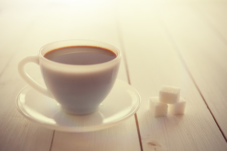 White coffee cup with rich coffee  on a white wooden tableの写真素材