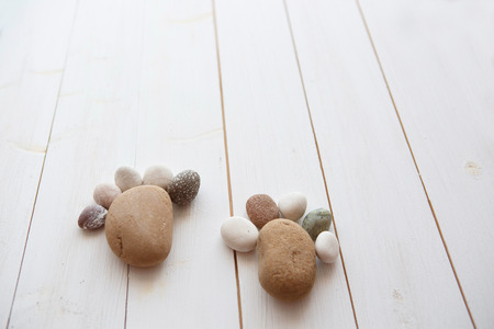 small beach stones laying on rustic wooden table useful as backgroundの写真素材