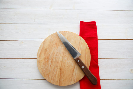 table with empty wooden cutting board and knifeの写真素材