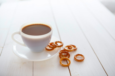 White coffee cup with rich coffee  on a white wooden tableの写真素材