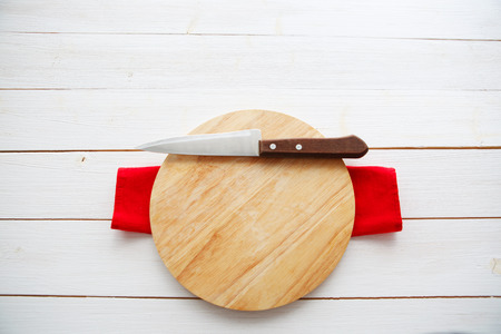 table with empty wooden cutting board and knifeの写真素材