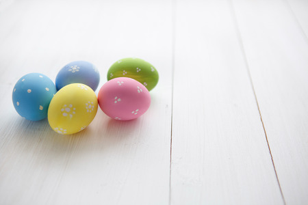 Colorful decorated easter eggs on white wood backgroundの写真素材