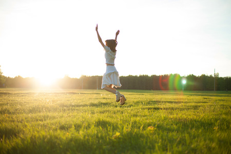 Young woman with spread arms looking upの写真素材