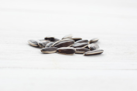 Sunflowers seeds on white wooden table の写真素材