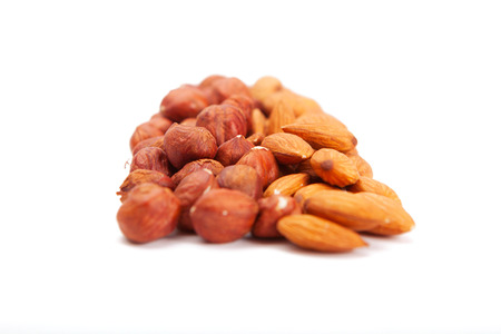 Pile of assorted nuts on white. Heap hazelnut and almonds  on a white background.の写真素材
