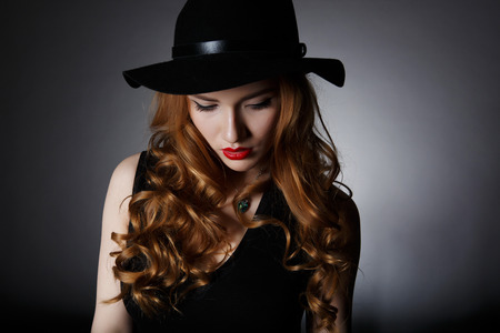 Beautiful Lonely Woman on the Dark Background of Dark Wallの写真素材