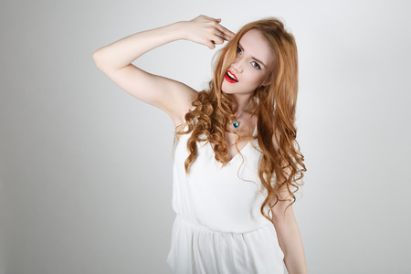 Depressed woman. Displeased young woman holding her hand like a gun near head and looking away whileの写真素材