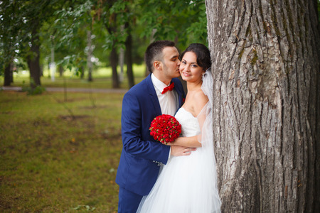 Young bride and groom together in the forest parkの写真素材